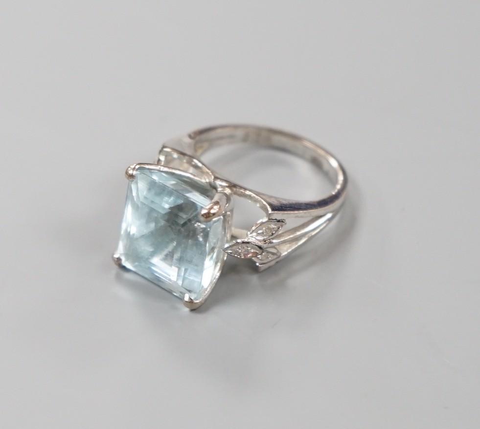 A white metal and single stone square cut aquamarine set dress ring, with diamond set shoulders, size K, gross weight 7 grams.